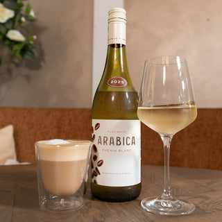 Arabica Flat White Chenin Blanc 2025 uit Zuid-Afrika met glas wijn en flat white.